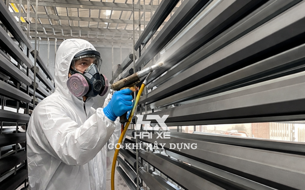 Hình ảnh thực tế thợ đang phun bột sơn tĩnh điện tại xưởng